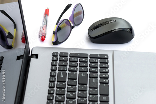 laptop and computer mouse, notebook and glass on table photo