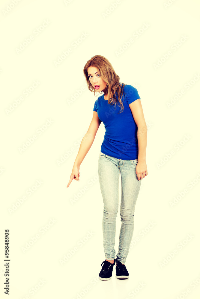 Beautiful young woman pointing down. Beautiful young woman pointing down.