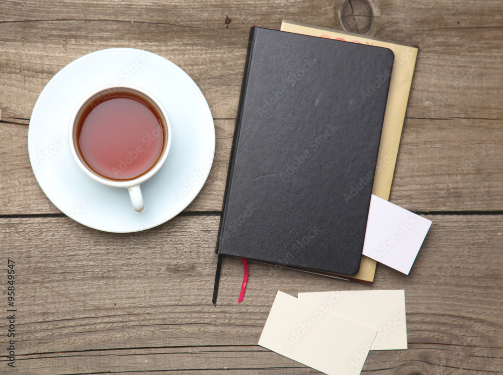 Blank business cards with pen and tea cup on wooden office table Blank business cards with pen and tea cup on wooden office table