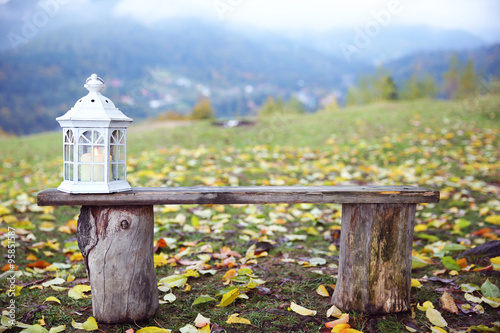 Old wooden bench with decorative lantern in mountains