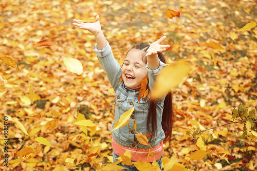 Happy young girl in autumn park