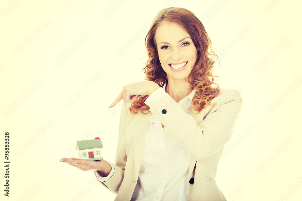 Businesswoman pointing on a model house. Businesswoman pointing on a model house.
