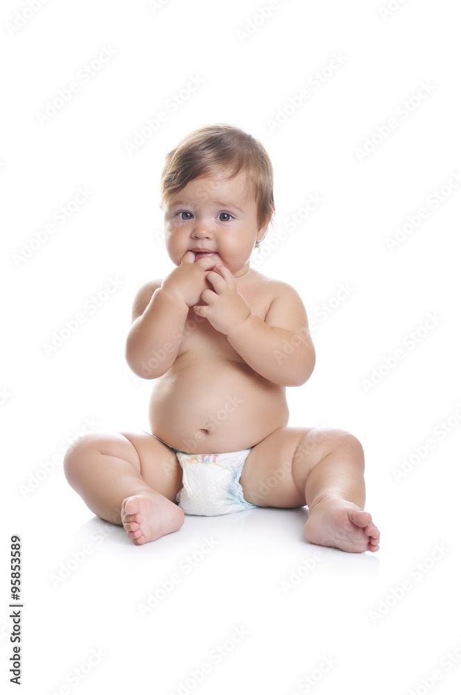 Adorable baby boy sitting with fingers in his mouth on a white background Adorable baby boy sitting with fingers in his mouth on a white background