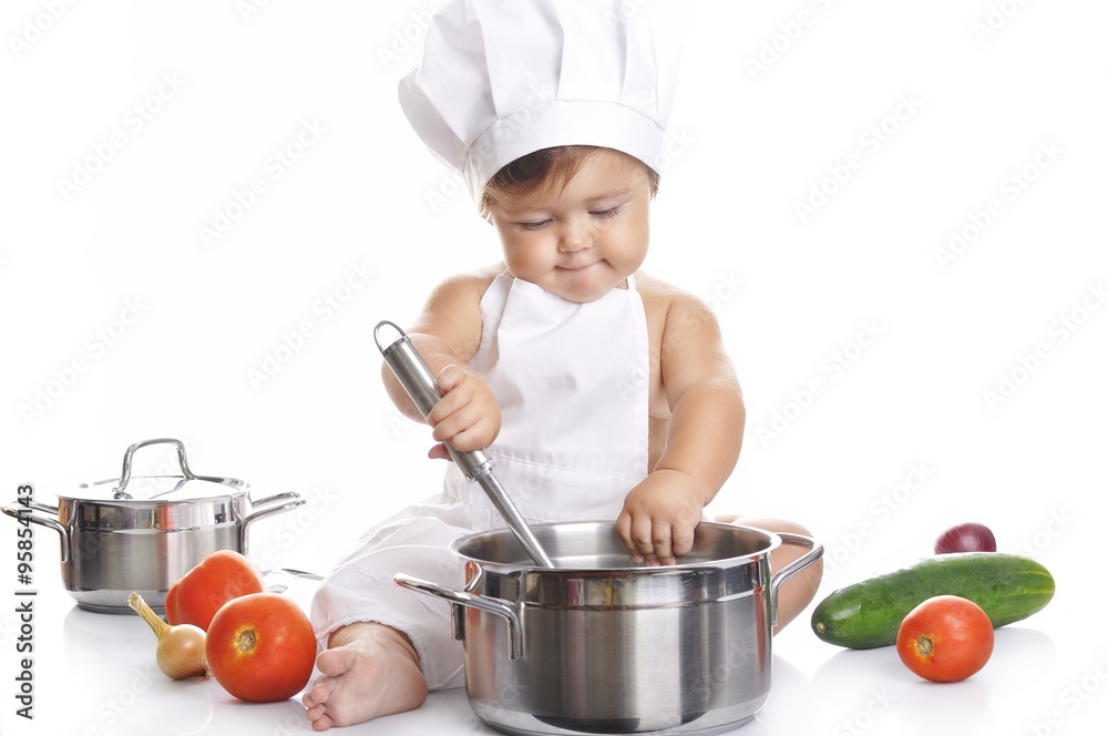 Funny adorable baby boy chef sitting and playing with kitchen equipment Funny adorable baby boy chef sitting and playing with kitchen equipment