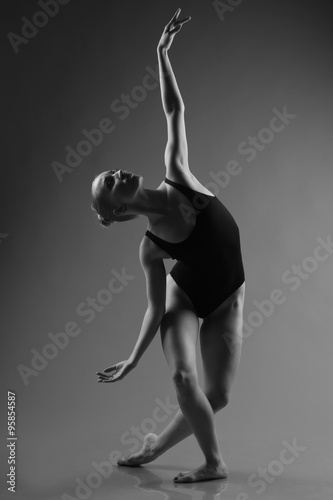 Fototapeta Naklejka Na Ścianę i Meble -  Modern ballet dancer posing on dark background