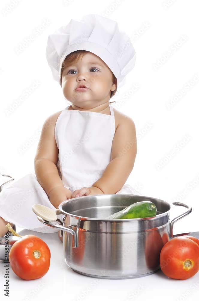 Funny adorable baby boy chef sitting and playing with kitchen equipment Funny adorable baby boy chef sitting and playing with kitchen equipment