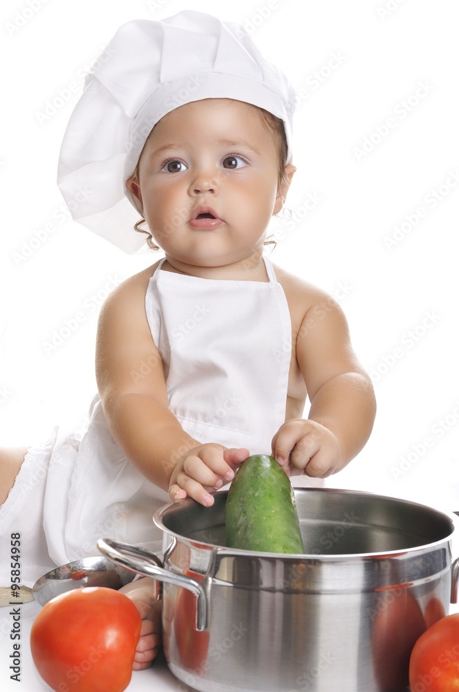 Funny adorable baby boy chef sitting and playing with kitchen equipment Funny adorable baby boy chef sitting and playing with kitchen equipment