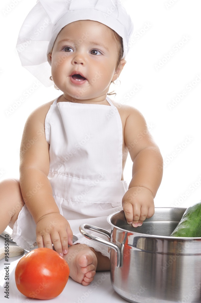Funny adorable baby boy chef sitting and playing with kitchen equipment Funny adorable baby boy chef sitting and playing with kitchen equipment