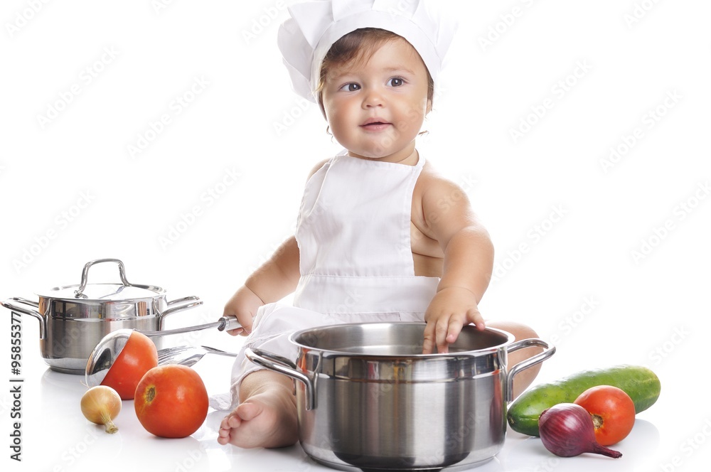 Funny adorable baby boy chef sitting and playing with kitchen equipment Funny adorable baby boy chef sitting and playing with kitchen equipment