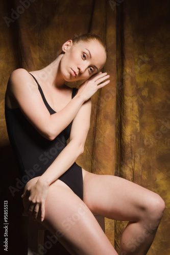 Modern ballet dancer posing in dark interior