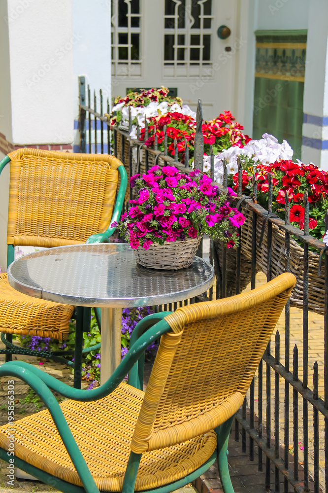 Fototapeta premium Small table and two chairs on a fenced terrace near the buildin