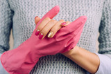 Woman in a gray sweater and bright manicure wearing pink rubber