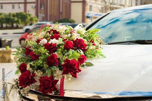 Wedding bouquet on the hood of the white car