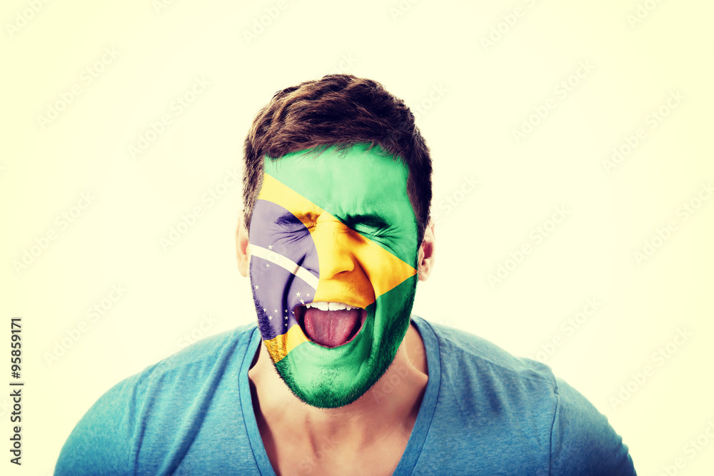 Screaming man with Brasil flag on face. Screaming man with Brasil flag on face.