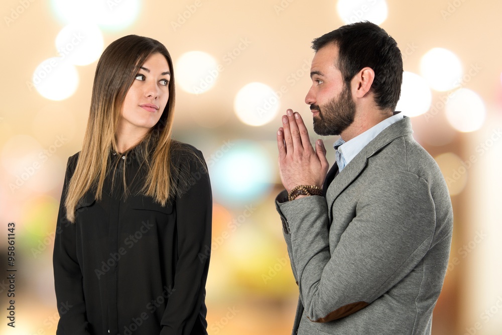 Men pleading at his girlfriend over white background Men pleading at his girlfriend over white background