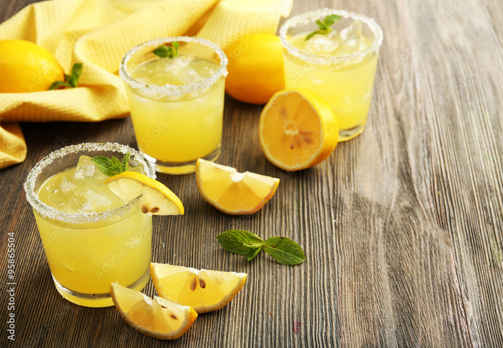 Glasses of lemon juice on wooden table, closeup Glasses of lemon juice on wooden table, closeup