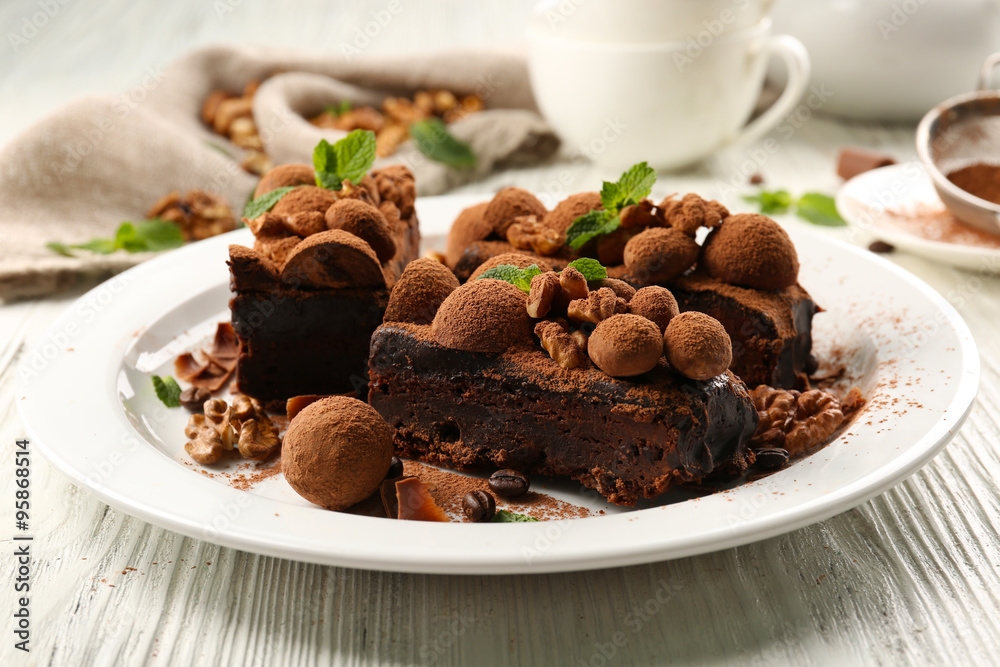 A piece of chocolate cake with walnut and mint on the table, close-up A piece of chocolate cake with walnut and mint on the table, close-up