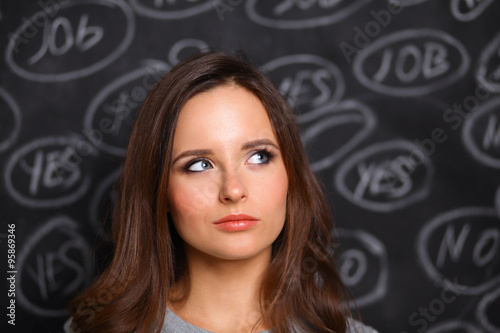 Thinking young woman with yes or no choice on gray background