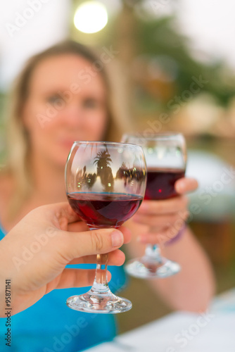 Man and woman clinking their glasses with red wine.