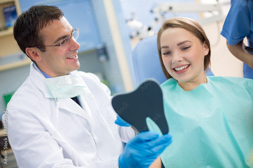 Dentist show teeth to girl with mirror Dentist show teeth to girl with mirror