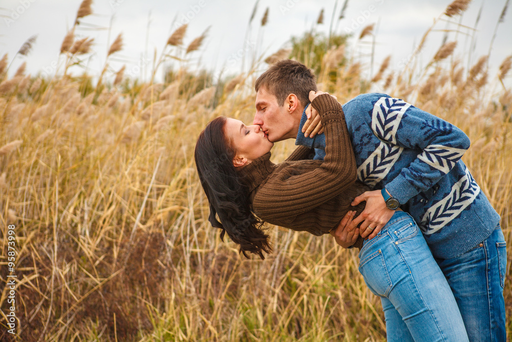 couple embraces on the shore of the pond in the park couple embraces on the shore of the pond in the park