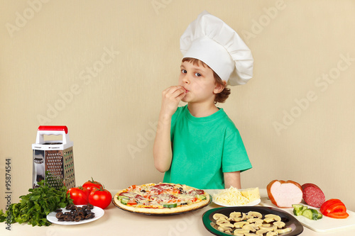 Young funny chef expressive enjoys a cooked pizza