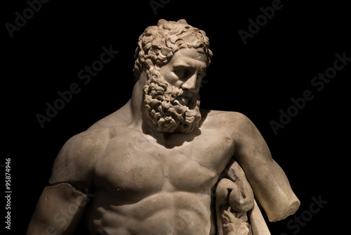 A statue of powerful Hercules, closeup, isolated in black photo