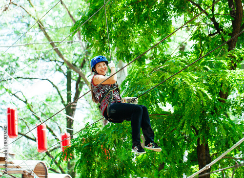 Adventure climbing high wire park - woman on course in mountain