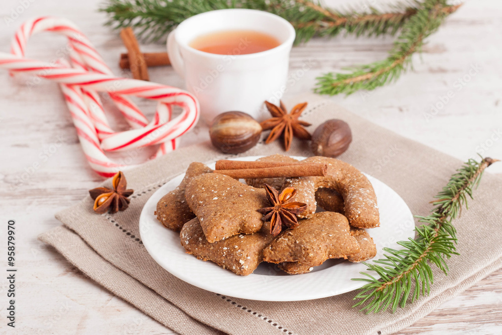 homemade gingerbread cookies on a plate, surrounded with spices,