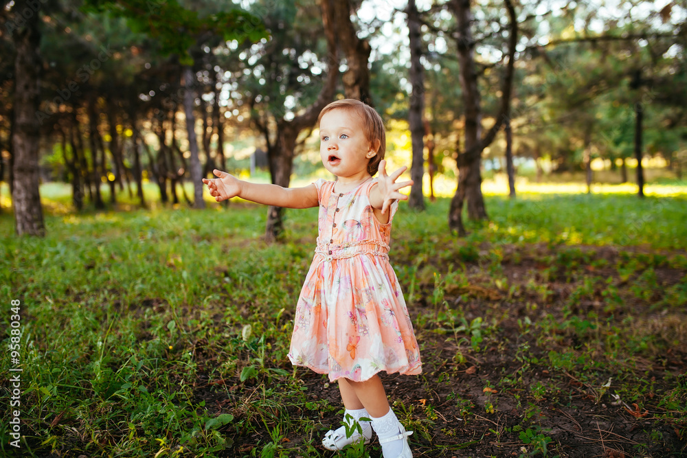 A cute little girl playing with soap bubbles in the park. A cute little girl playing with soap bubbles in the park.