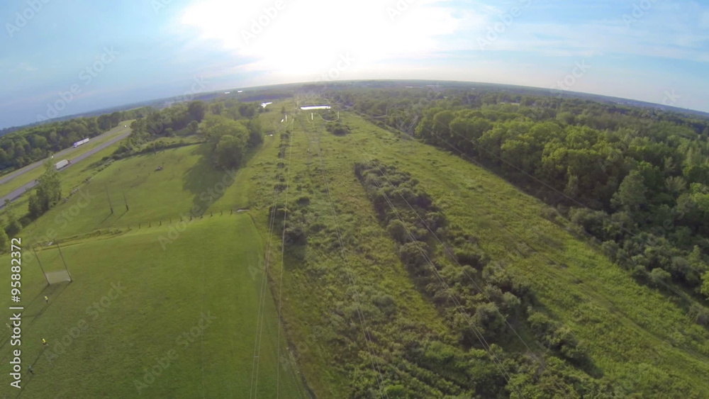 Power Lines Aerial in Field. camera flys over electrical power lines in slow motion towards the sun. over green fields and thruway on the left
Power Lines Aerial in Field. camera flys over electrical power lines in slow motion towards the sun. over green fields and thruway on the left