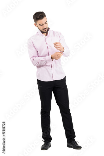 Young bearded groom getting dressed for wedding. Full body length portrait isolated over white studio background. 