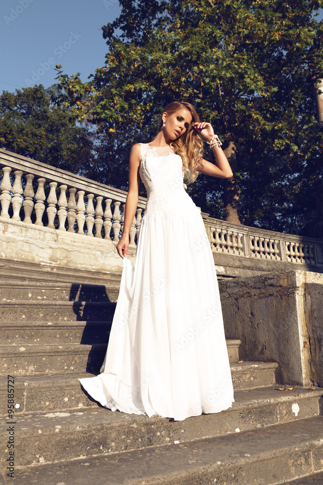 beautiful blond woman wears wedding dress,posing beside antic villa beautiful blond woman wears wedding dress,posing beside antic villa