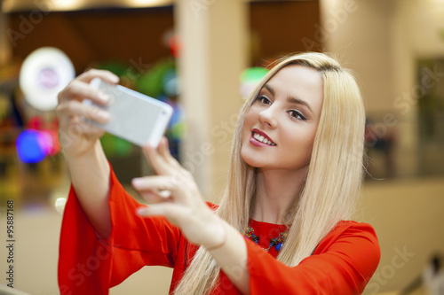 Young beautiful blond woman taking selfie with mobile phone