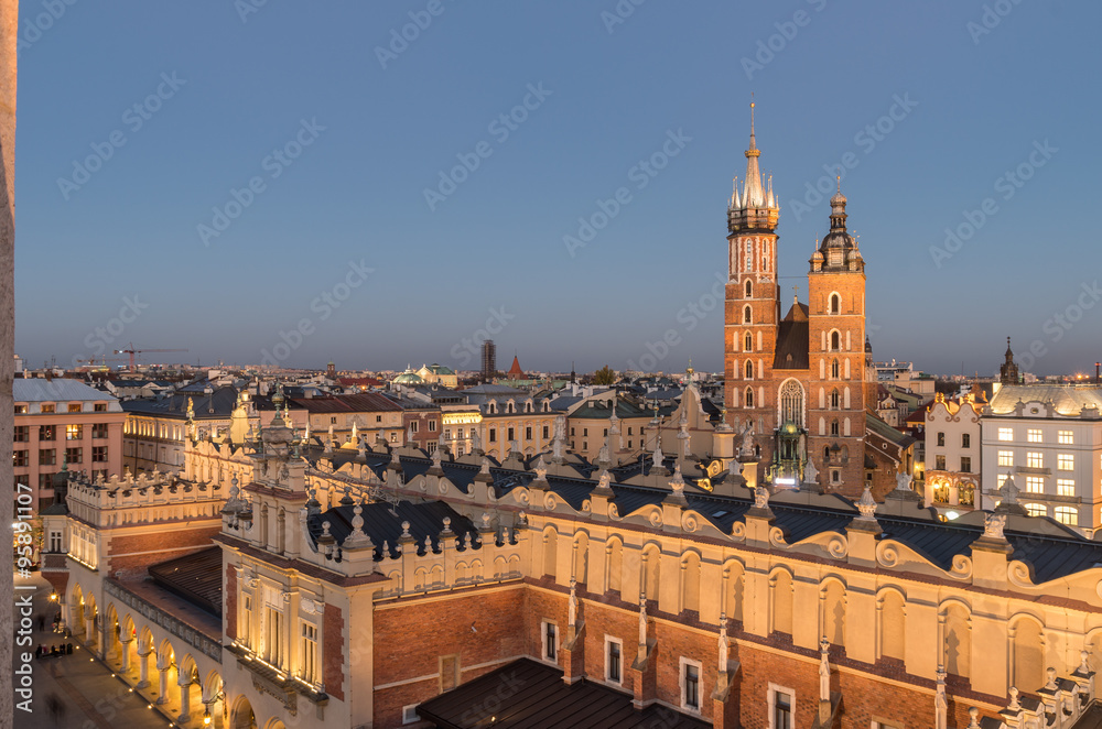 Krakow, Poland, Virgin Mary church on the Main Market Square seen over Sukiennice (Cloth Hall) from the Town Hall tower in the night