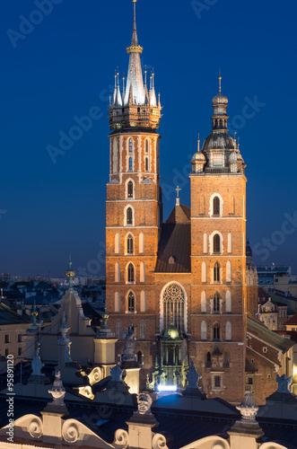 Krakow, Poland, Virgin Mary church on the Main Market Square seen over Sukiennice (Cloth Hall) from the Town Hall tower in the night