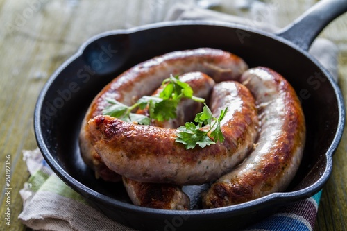 Grilled sausages on pan with herbs and spices