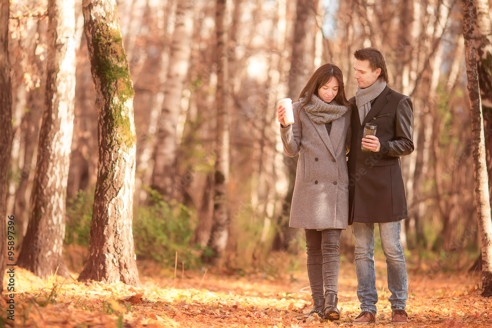 Happy family walking in autumn park on sunny fall day Happy family walking in autumn park on sunny fall day