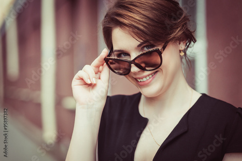 Close-up of beautiful brunette model in stylish sunglasses