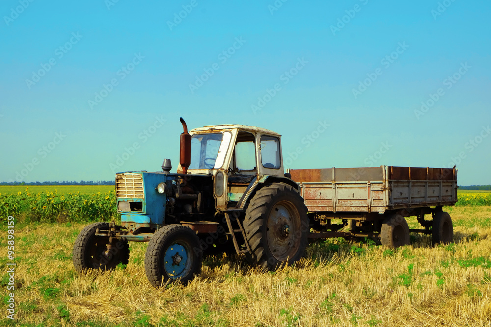 Tractor in field on blue sky background Tractor in field on blue sky background