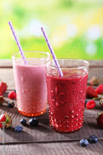 Wallpaper Mural Glasses of berry smoothie on wooden table on blurred background Torontodigital.ca