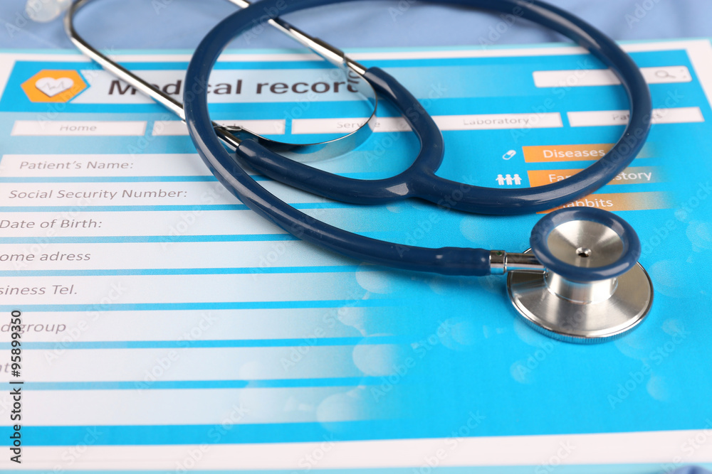 Medical stethoscope and clipboard on blue background