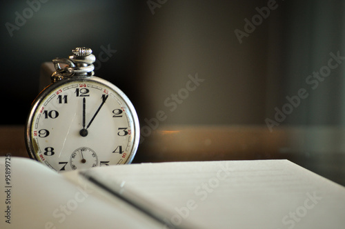 Pocket watch next to notebook. symbols of time