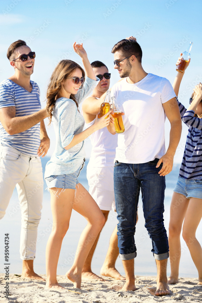 Obraz premium Young people with beer on the riverside
