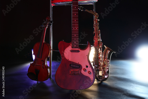 Beautiful golden saxophone and guitar near bar stool on a scene
