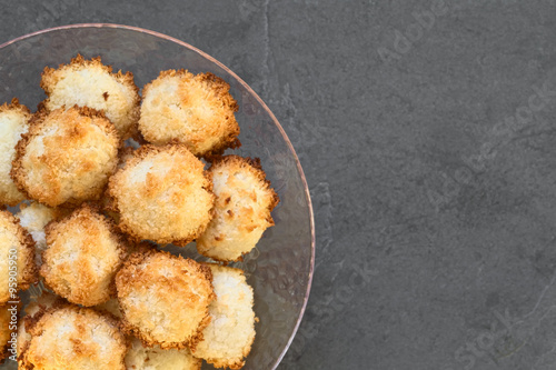 Homemade coconut macaroons (coconut meringue cookies), traditional German Christmas cookies called Kokosmakronen, photographed with natural light (Selective Focus, Focus on the top macaroons) photo