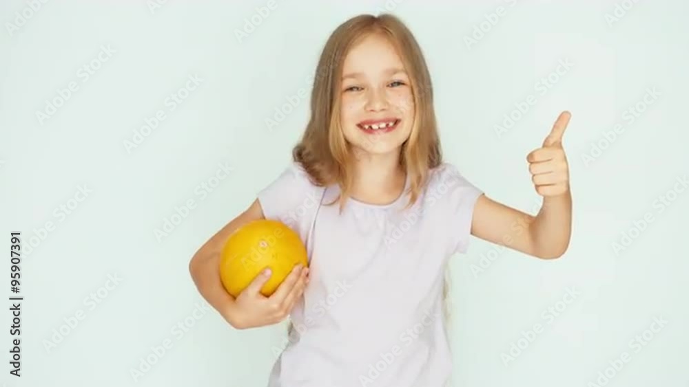 Girl holding melon and playing with berry. Thumb up. Ok Girl holding melon and playing with berry. Thumb up. Ok