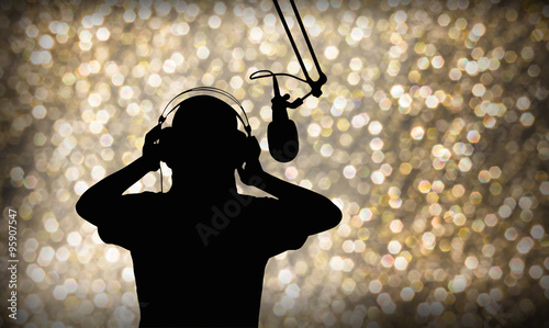 Entertainment background with silhouette of  singing or singer with headphone and microphone on beautiful bokeh  light in party and joyful event night or superstar search contest concept 