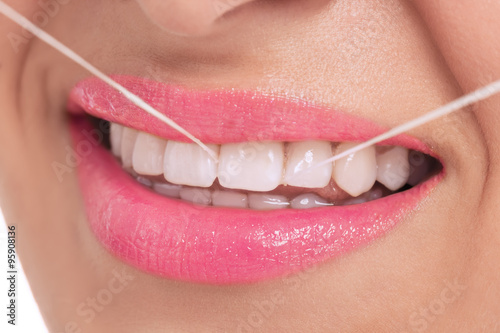 Woman cleaning her teeth with dental thread
