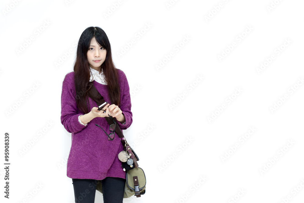 Fototapeta premium Asian girl in casual wear playing moblie phone
